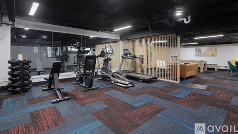 A gym with a variety of equipment including treadmills, weights, and exercise machines.