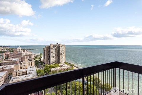 A balcony overlooks a cityscape and a body of water.