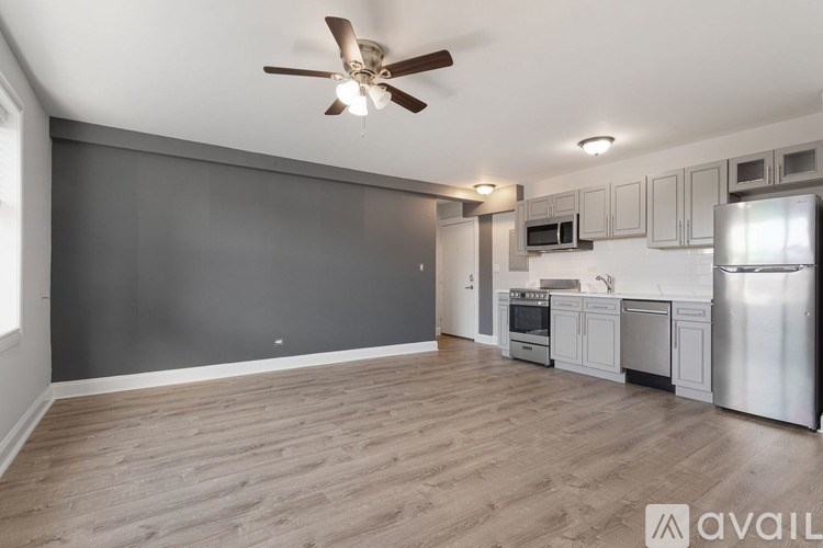 A kitchen with a refrigerator, microwave, and oven.