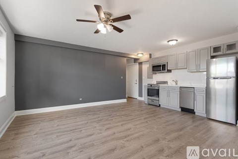 A kitchen with a refrigerator, microwave, and oven.