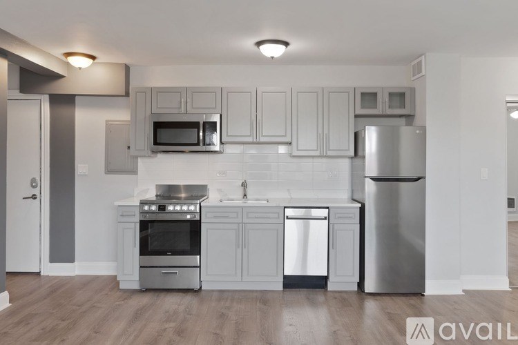 A modern kitchen with stainless steel appliances and white cabinetry.
