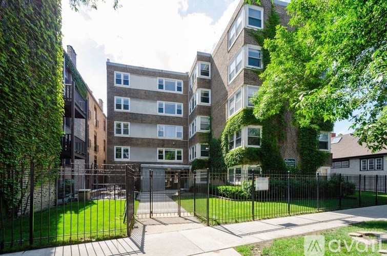 A large building with a green hedge on the side.