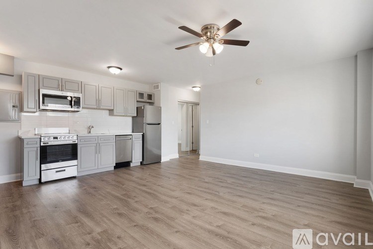 A spacious kitchen with a fan on the ceiling.