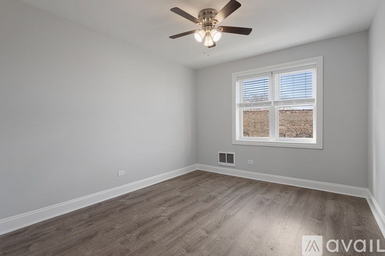 A room with a ceiling fan and a window with blinds.