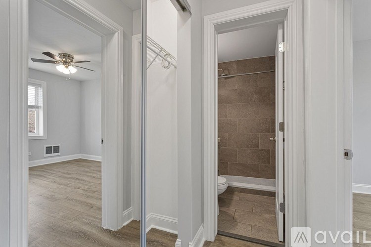 A bathroom with a walk-in shower and a fan.