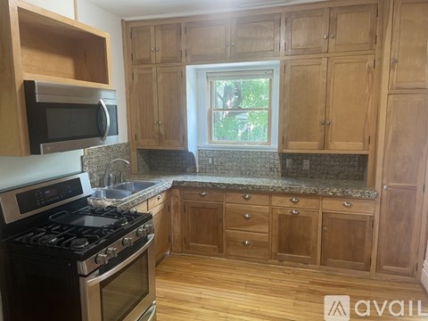 A kitchen with wooden cabinets and a black stove top oven.
