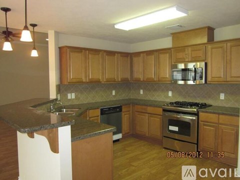 A kitchen with wooden cabinets and a granite countertop.