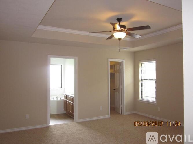 A room with a ceiling fan and carpeted floor.