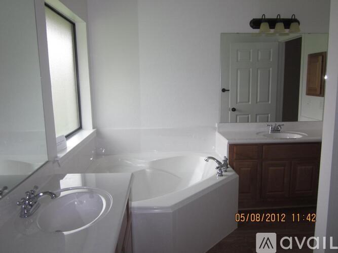 A bathroom with a tub, sink, and mirror.