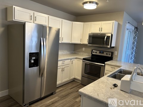 A kitchen with a stainless steel refrigerator, microwave, oven, and sink.