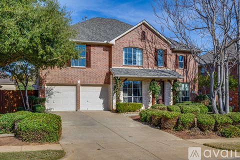 A house with a brick facade and a white garage door is for sale.