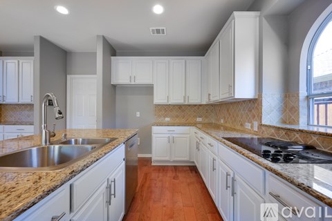A kitchen with white cabinets and a granite countertop.