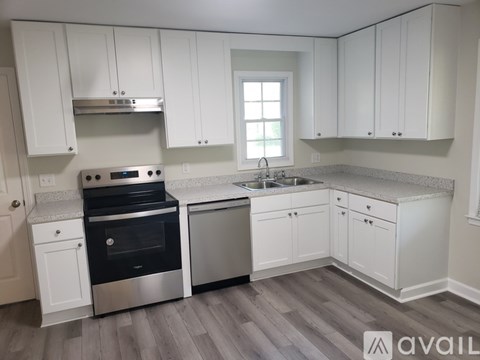 A kitchen with white cabinets and a stainless steel oven.