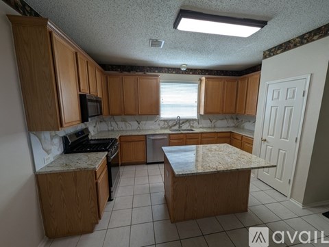 A kitchen with wooden cabinets and a granite countertop.