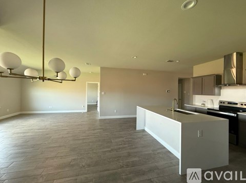A spacious kitchen and living room with a large island in the middle.