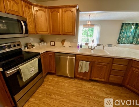 A kitchen with wooden cabinets and a black stove top oven.
