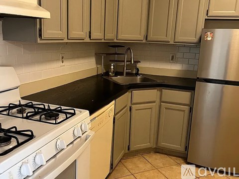 A kitchen with a stove, sink, and refrigerator.