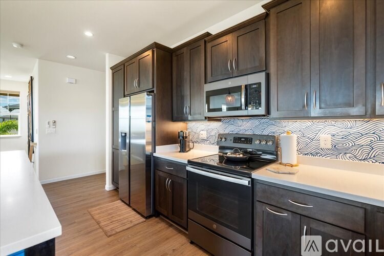 A kitchen with dark wood cabinets and a white countertop.