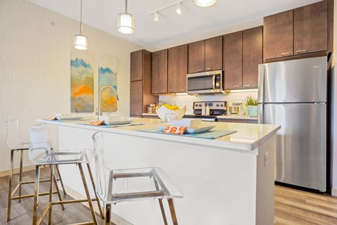 A kitchen with a white counter top and a stainless steel refrigerator.