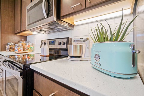 A kitchen with a blue toaster on the counter.