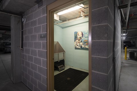 A room with a painting on the wall and a doorway leading to another room.