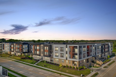Apartment complex with a mix of grey, brown, and red balconies.