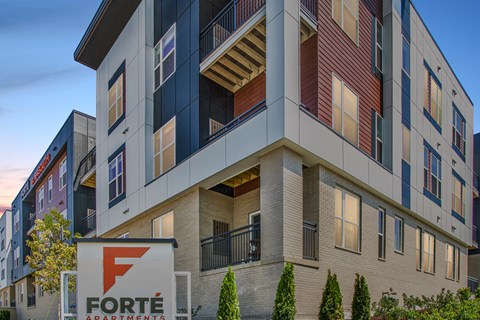 A multi-story building with a sign that says "Forté Apartments".