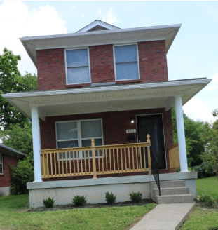 A red brick house with a white porch.