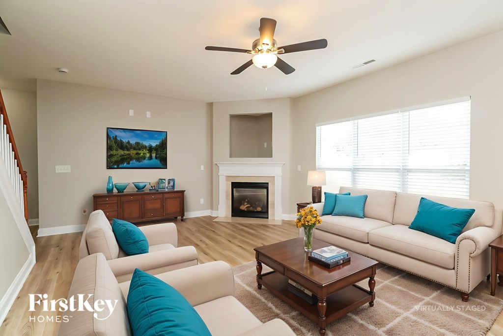 A living room with a fireplace and a painting on the wall.