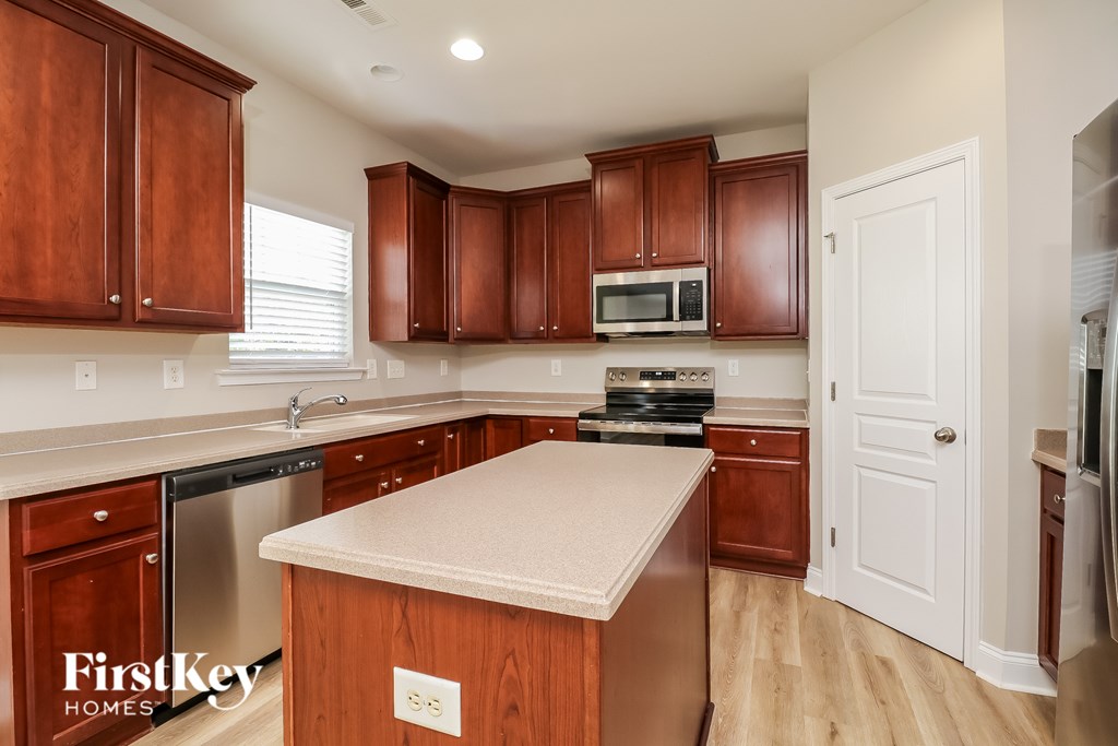A kitchen with wooden cabinets and a white island.