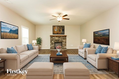 A living room with a fireplace and a painting of a mountain scene on the wall.