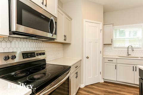 A kitchen with a stove top oven and microwave above it.