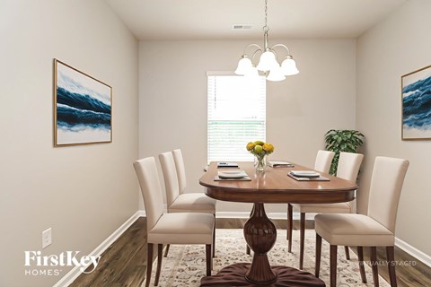 A dining room with a wooden table and chairs.