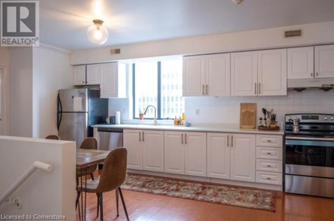 A kitchen with white cabinets and a rug on the floor.