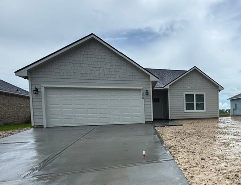 A house with a grey garage door and a grey roof.