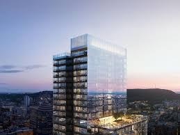 A modern glass skyscraper stands tall against a twilight sky.