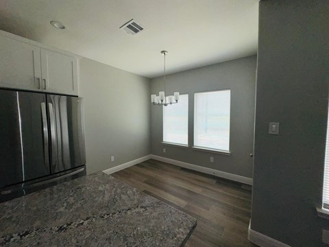 A kitchen with a granite counter top and a refrigerator.