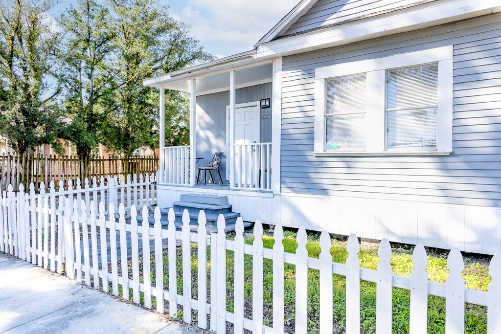 A house with a white picket fence and a small porch.