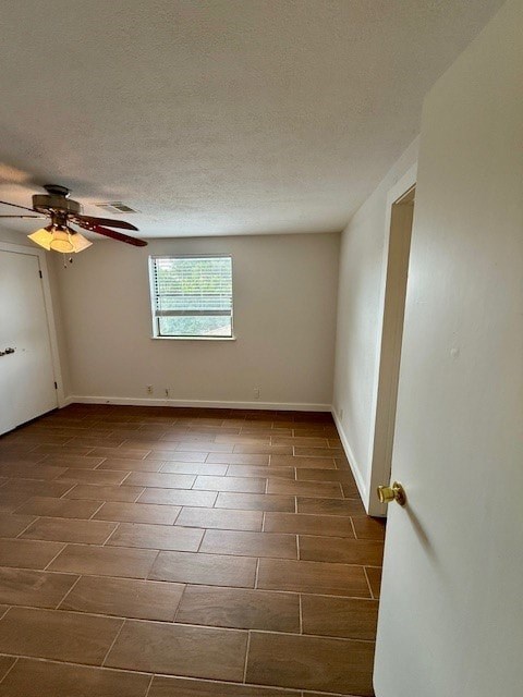 A room with a ceiling fan and tile flooring.