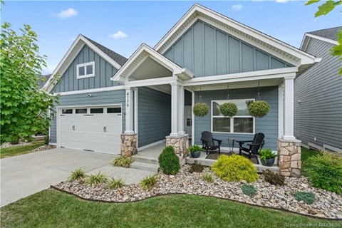 A house with a grey garage door and a white roof.
