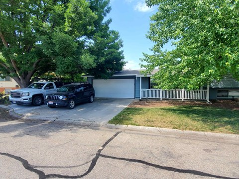 A black Jeep is parked in a driveway.