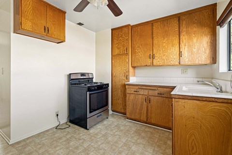 A kitchen with wooden cabinets and a black stove top oven.