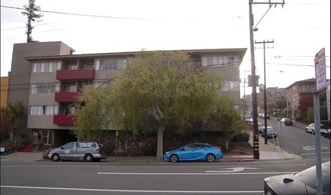 A blue car is parked on the side of the street.