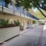 A long building with a balcony and plants on it.