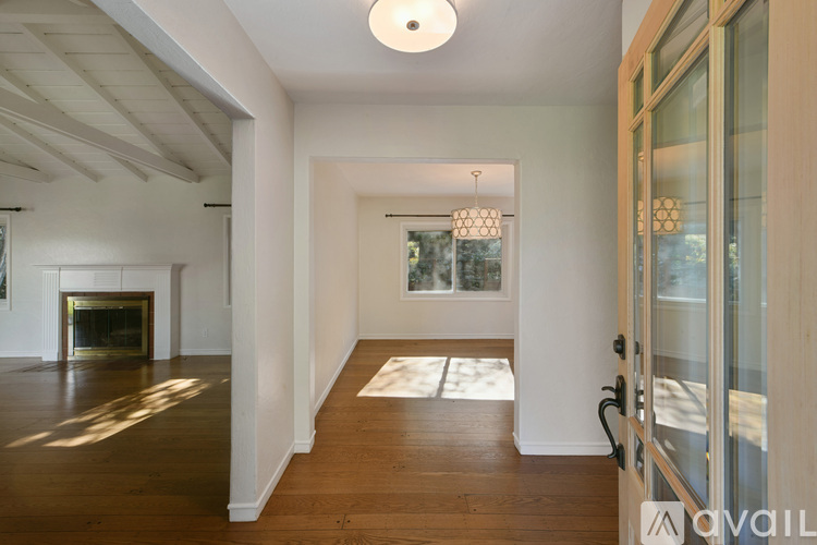 A spacious room with a fireplace and a glass door leading to another room.