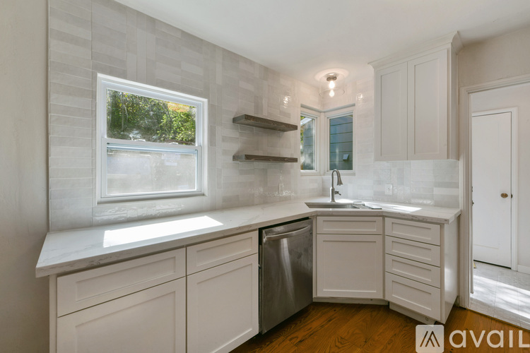 A kitchen with white cabinets and a window.