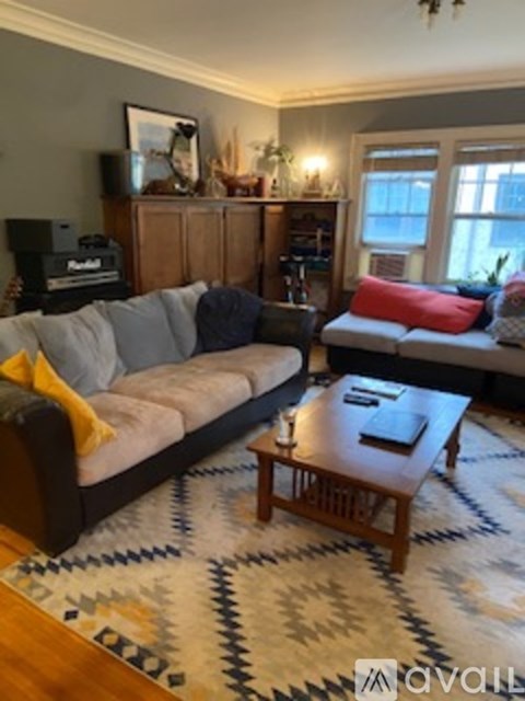 A living room with a grey sofa and a wooden coffee table.