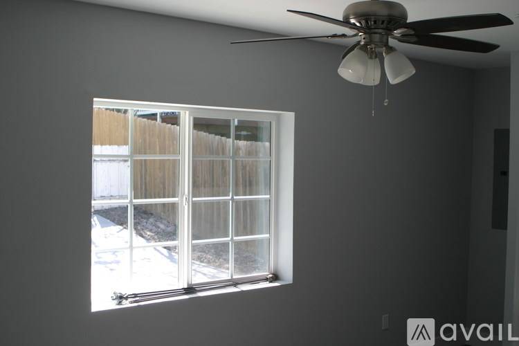 A room with a ceiling fan and a window.