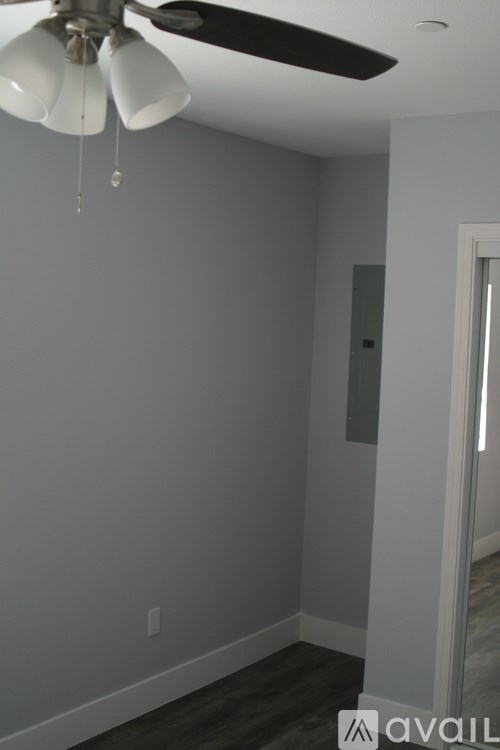 A room with a ceiling fan and a door.