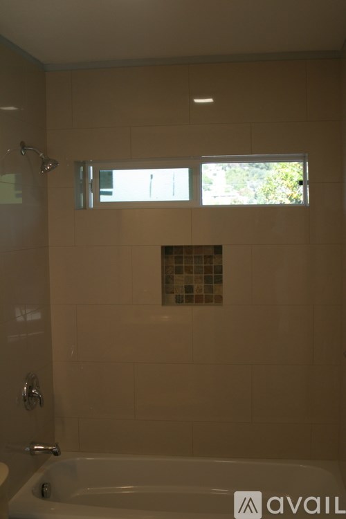 A bathroom with a tub and a window.